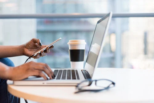 Person using a MacBook Air on a table. Person using a MacBook Air on a table.