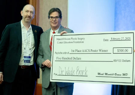 Dr. Wade Brock is getting the check of $500 for winning the poster contest.